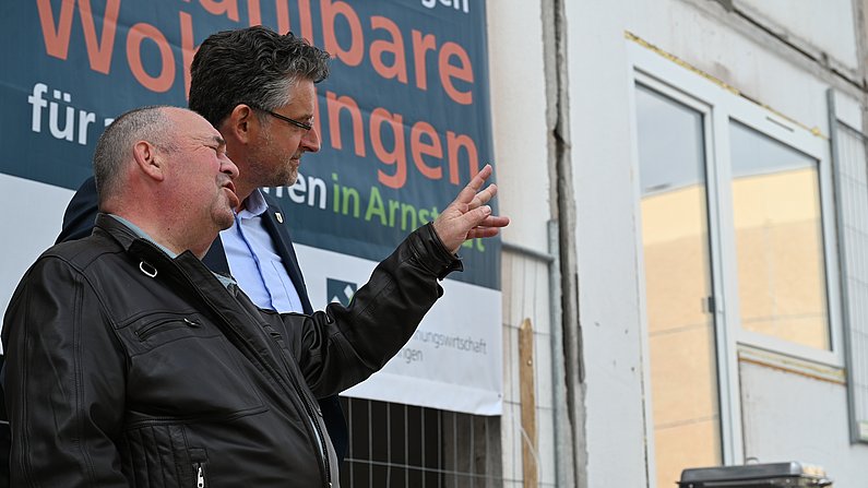 Auf dem Foto sind zwei Personen zu sehen die sich unterhalten.