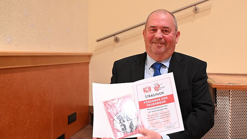 Auf dem Bild ist der Geschäftsführer der WBG Arnstadt, Detlef Möller, zu sehen. Er hält eine Urkunde als Förderer der Feuerwehr in den Händen. 