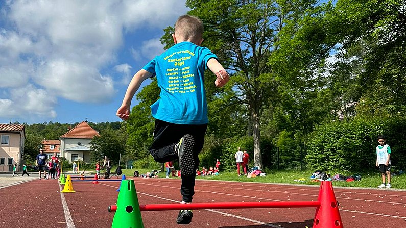 Auf dem Bild ist ein Kind beim Sportfest zu sehen. 