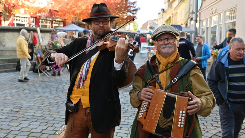 Auf dem Bild sind zwei Musiker zum Herbst- und Bauernmarkt zu sehen. 