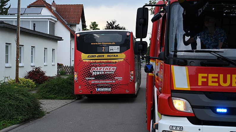 Auf dem Bild ist ein Feuerwehrauto mit einem Bus zu sehen. 