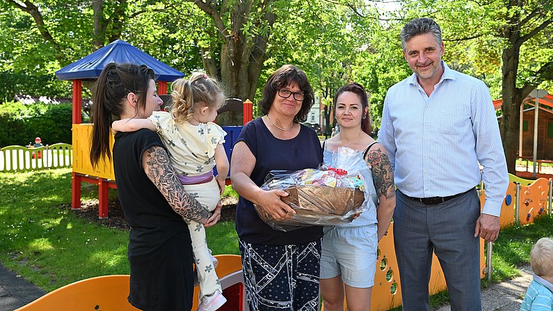 Auf dem Bild ist Bürgermeister Frank Spilling mit dem Team der Kinderkrippe Regenbogen zu sehen. 