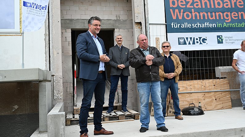 AUf dem Foto sind mehrere Personen zu sehen. Das Foto wurde während eines Richtfestes aufgenommen. 