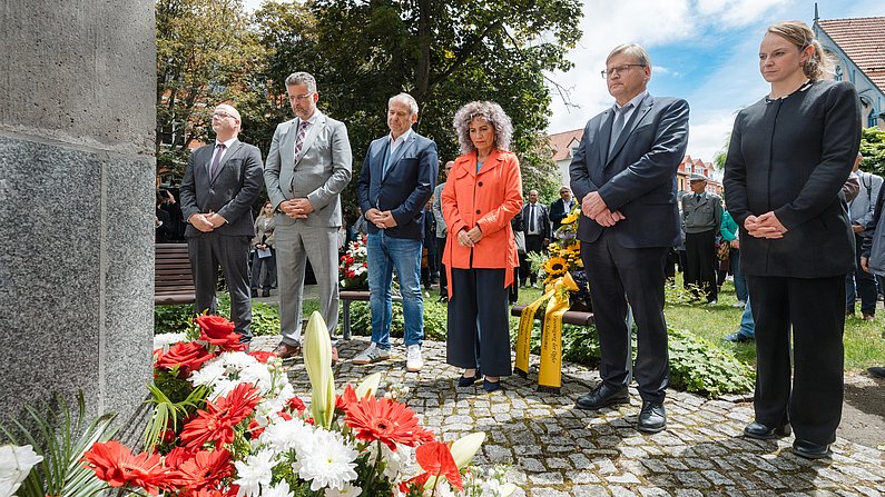 Auf dem Bild sind Vertreter aus Politik zu sehen, die an einem Denkmal stehen. 