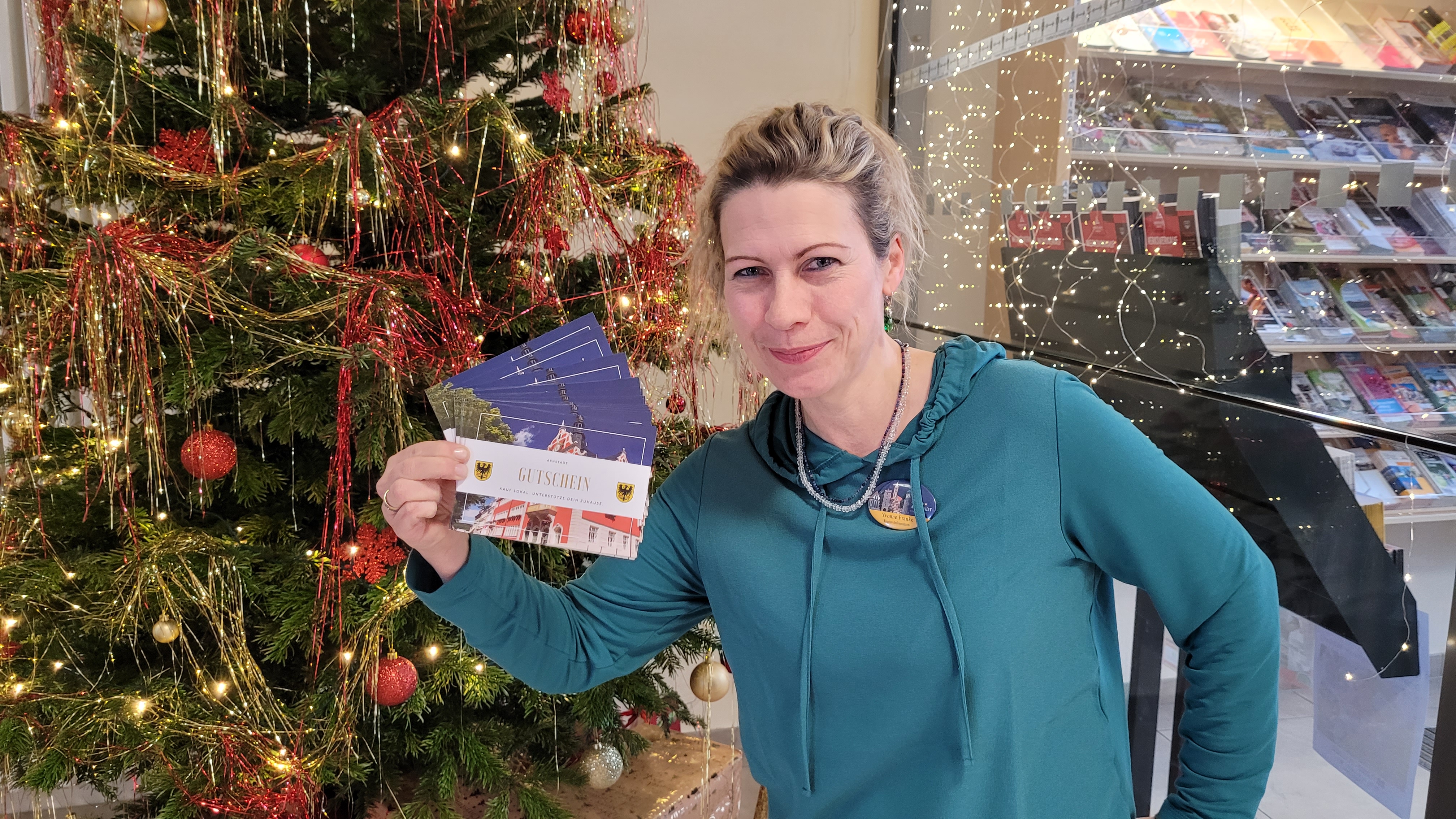Yvonne Franke von der Tourist-Information zeigt den Arnstadt-Gutschein.